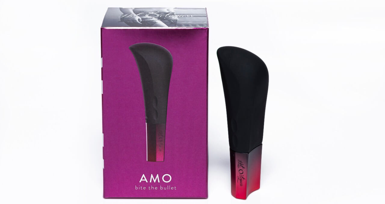 The red and black bullet vibrator Amo from Hot Octopuss stands straight, next to its packaging.