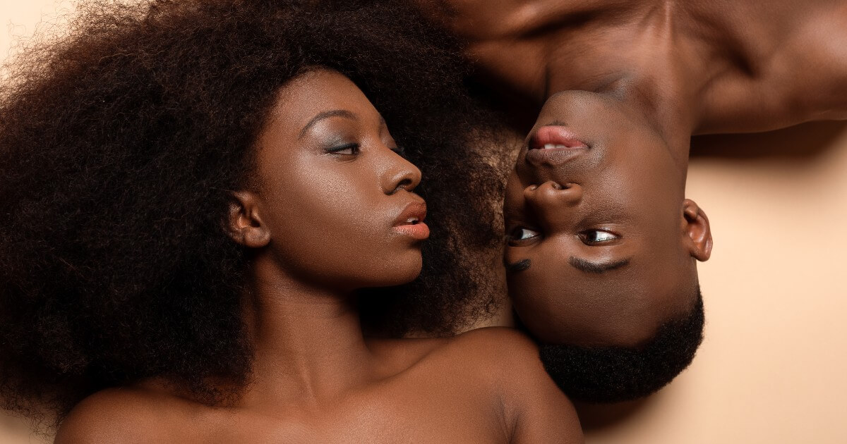 A young Black couple look into each other's eyes.