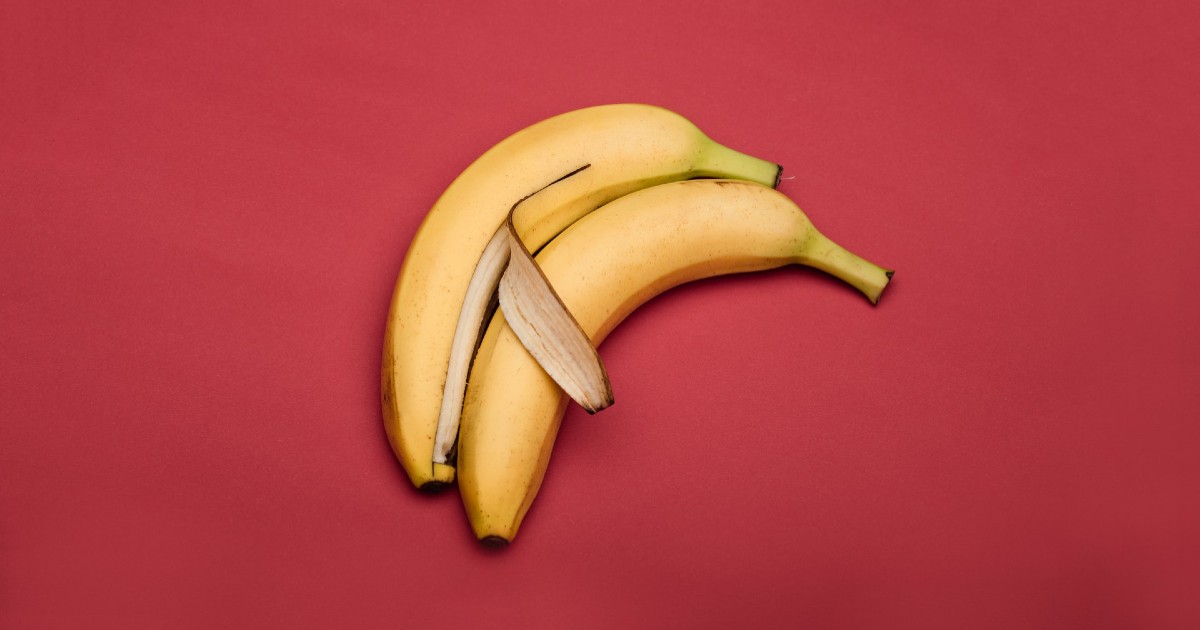 Image of two bananas placed together, one of which is partially peeled