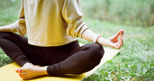 Woman sitting in a meditation pose.