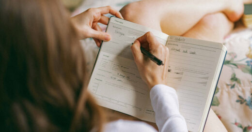 woman with cannabis journal for patients from Goldleaf journals while in bed