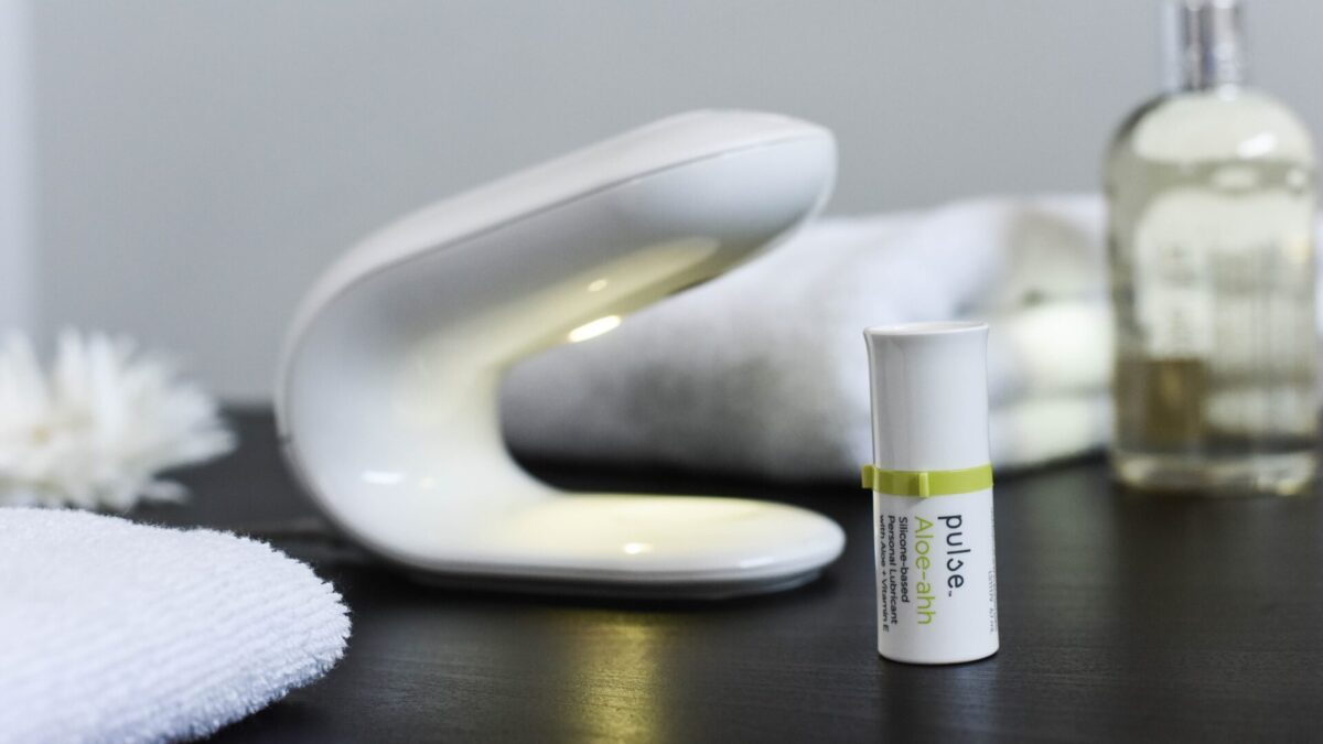pulse lube dispenser on spa table next to silicone-base personal lubricant with Aloe. 